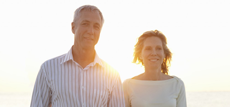 Middle aged couple walking together with sun behind them