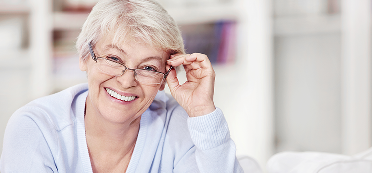 Smiling middle aged woman adjusting her glasses