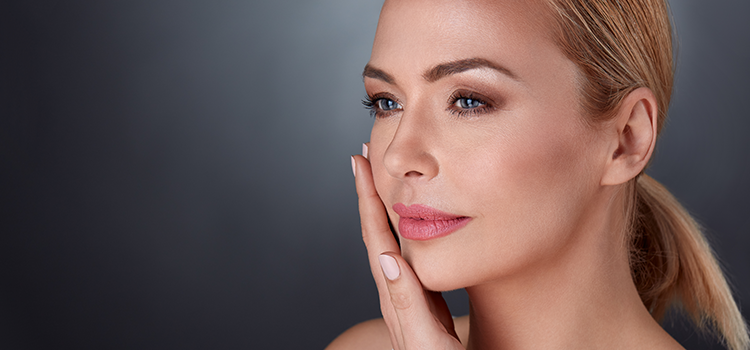 Woman with smooth skin looking pensive with hand on her face