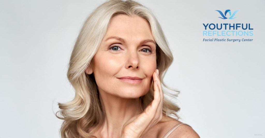 Mature woman smiling and touching her cheeks. (Model)