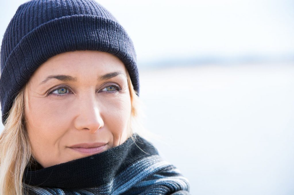 Woman in knit cap and sweater looking to the right