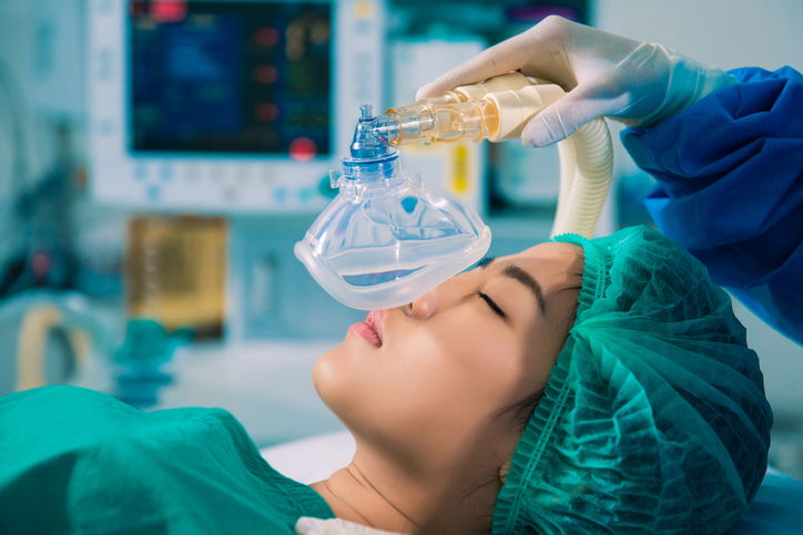 Young asian woman on OR table about to be placed under general anesthesia.