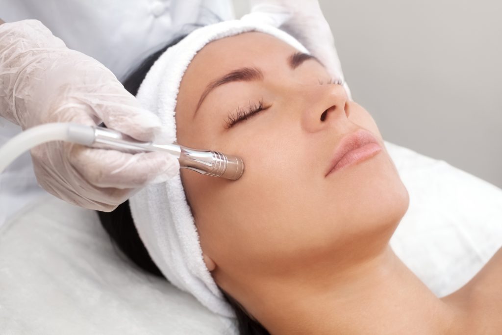 Woman's face with eyes closed as she gets microdermabrasion