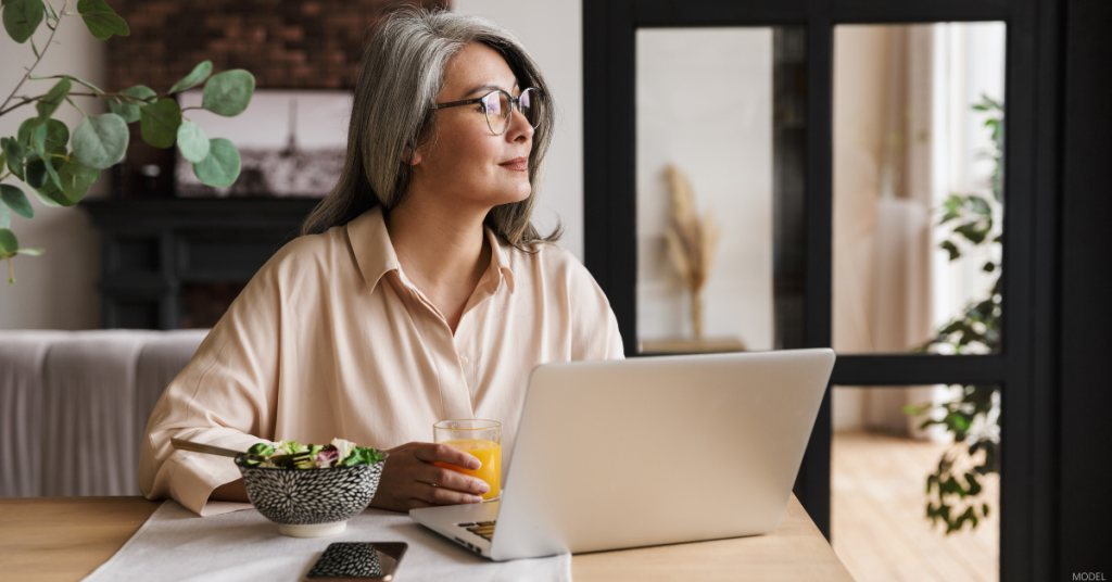 A woman researches facial plastic surgeons on her computer.