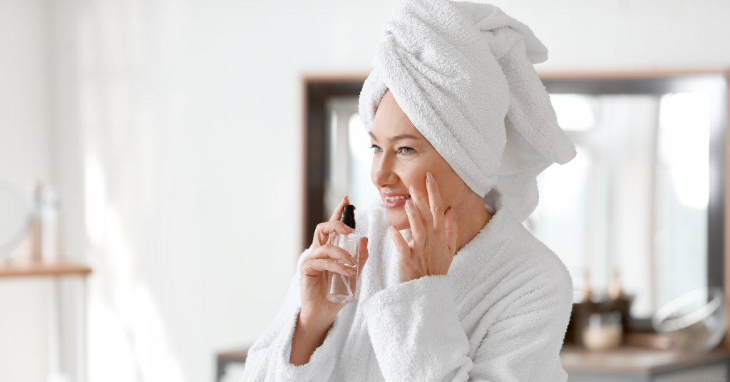 A woman applies skin care product to her face after facelift surgery.