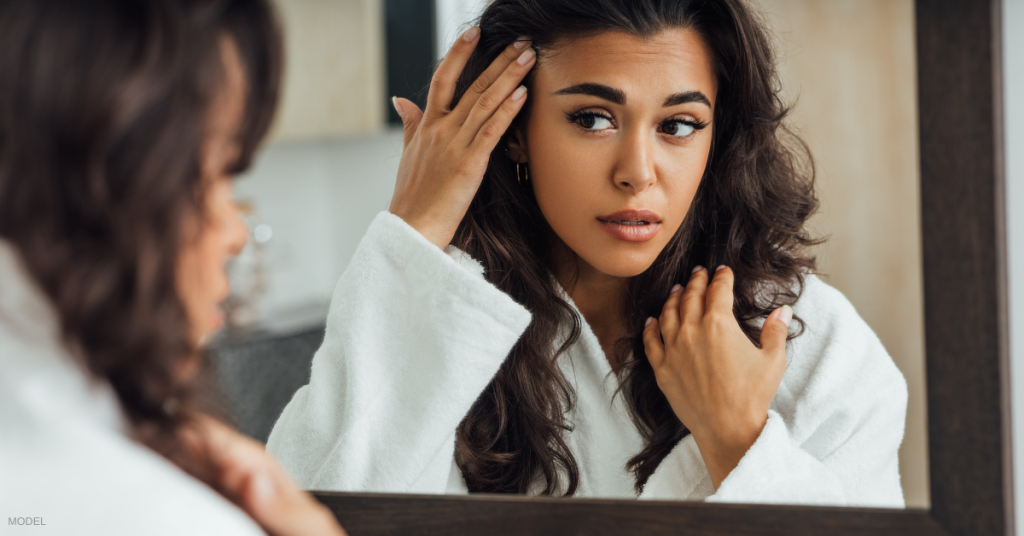 Woman looking at her reflection in mirror