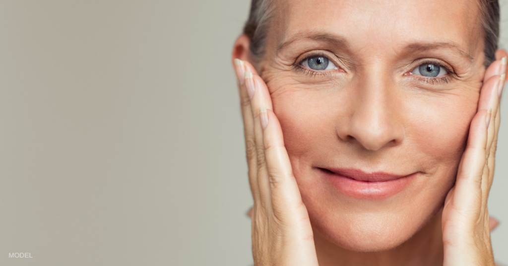 Woman holding her face and smiling (model)