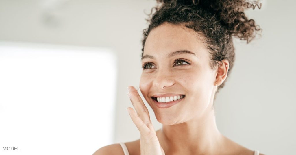 A woman putting on her skincare (model)