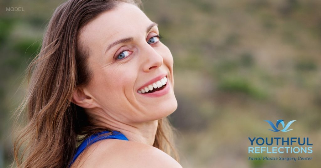 woman with clear skin outside after getting laser skin treatments (model)