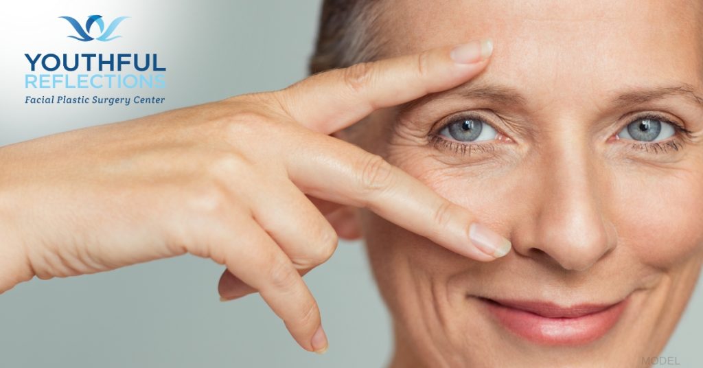 woman framing her eyes with her hands after blepharoplasty (model)